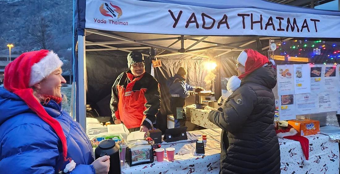 Yada Thaimat i telt på Lærdalsmarknaden, med gjester foran disken.
